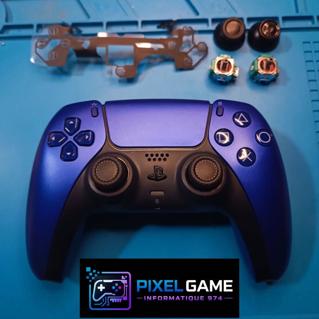 Manette PS5 violette ouverte sur le tapis d'atelier, joysticks de rechange à côté